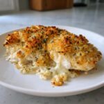 A close-up of a perfectly baked Garlic parmesan chicken bake with a crispy, golden crust and melted sauce.