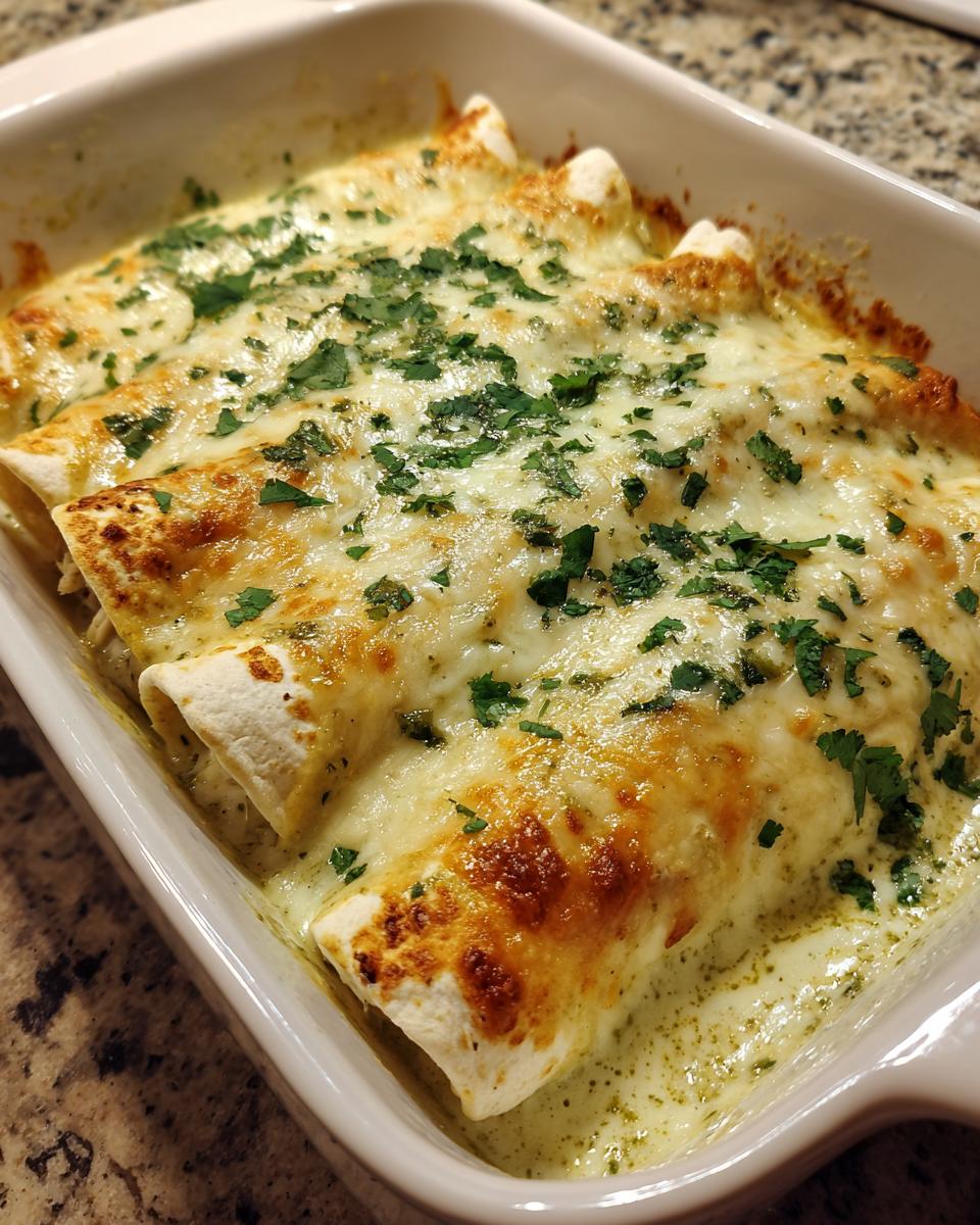Close-up of baked green chile chicken enchiladas covered in melted, bubbly cheese and fresh cilantro.