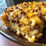 Close-up of a baked cheeseburger casserole featuring macaroni, ground beef, and a thick layer of melted cheddar cheese.