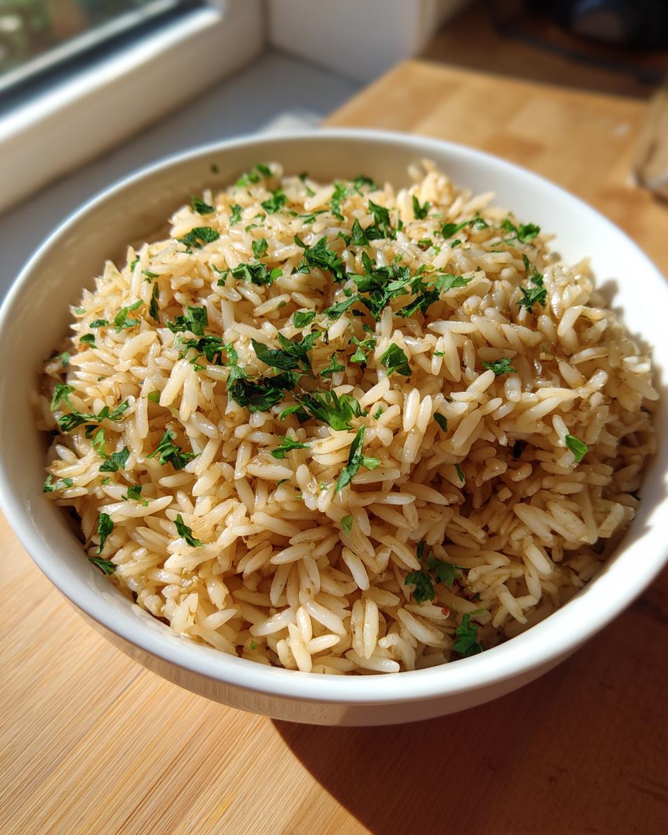 A close-up of fluffy, perfectly cooked rice pilaf garnished with fresh chopped parsley in a white bowl.