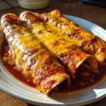 Three rolled cheese enchiladas smothered in rich red sauce and melted yellow cheese.
