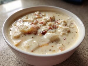 Close-up of a bowl of rich, velvety crab soup filled with chunks of white crab meat and herbs.
