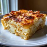 A perfect slice of rich, creamy ruth chris potatoes au gratin showing layers of potato and a deeply browned, cheesy crust.