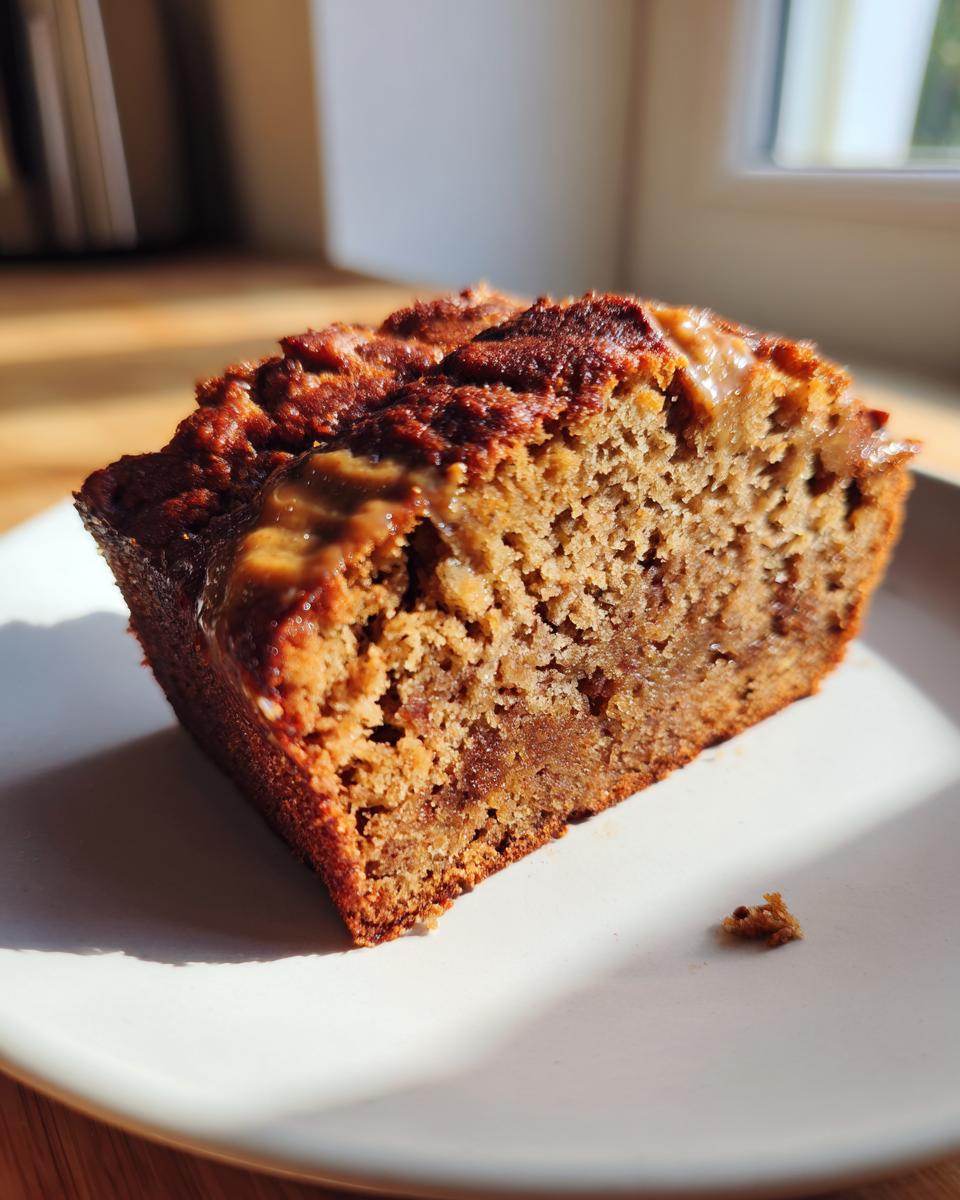 Close-up of a moist slice of gluten free peanut butter banana bread with a melted peanut butter drizzle on top.